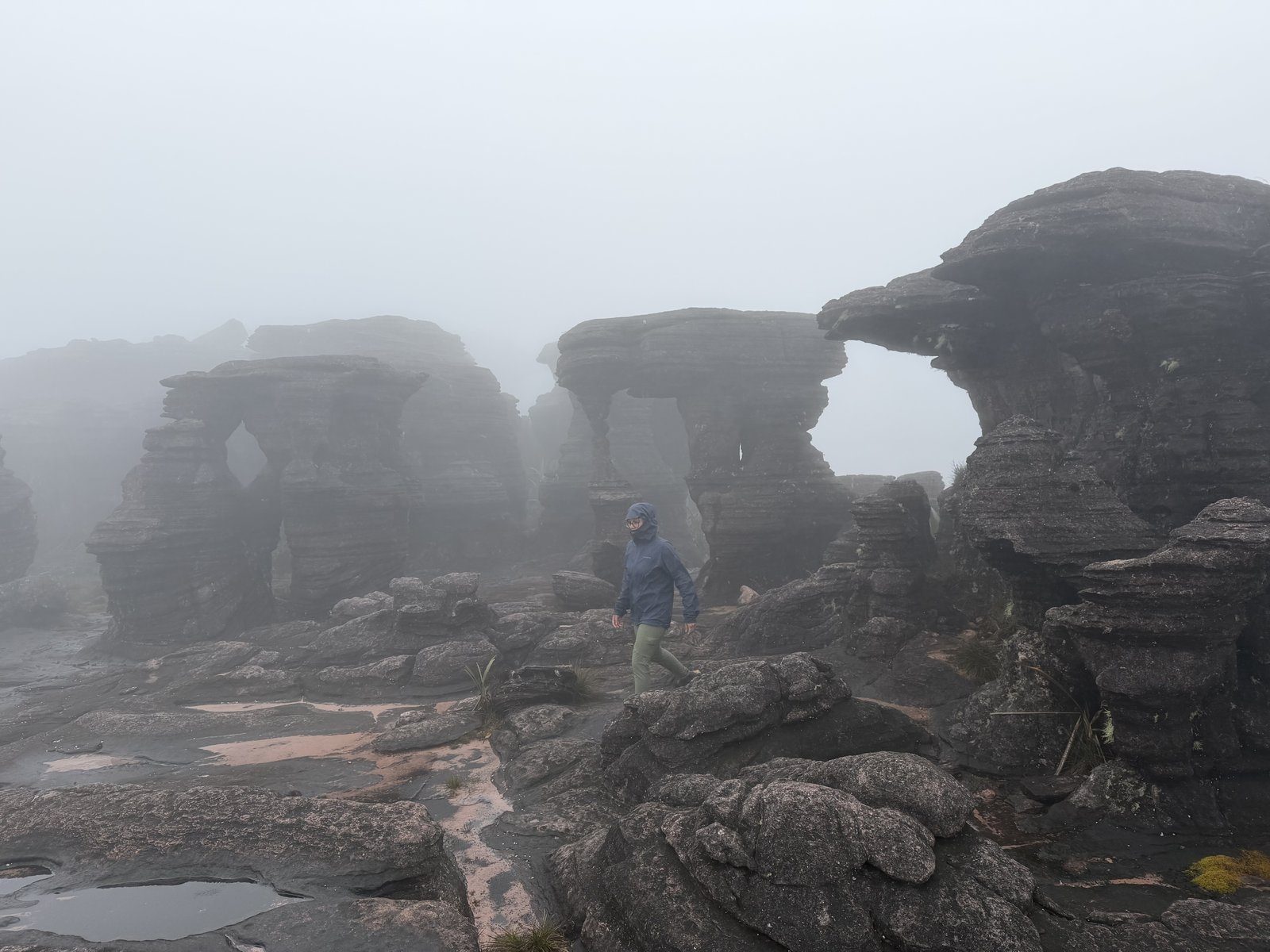 Ventana de roca envuelta en niebla en la cima